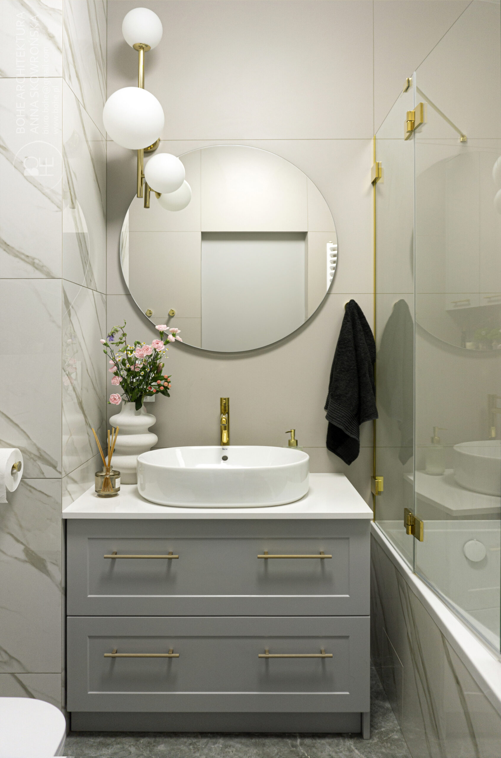 łazienka ze złotymi detalami i okrągłym lustrem architekt białystok